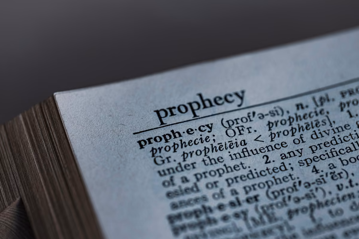 Close-up of the definition of the word 'prophecy' printed on a dictionary page.